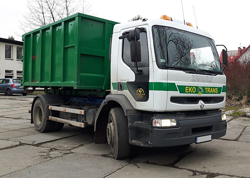 Samochód hakowy z zielonym kontenerem 8 m³ na drodze